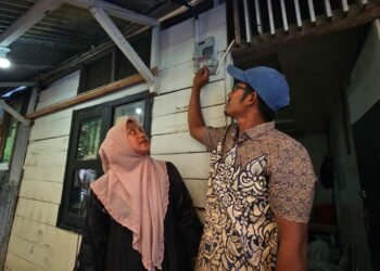 Ferra (kiri) dan suaminya, Taufik (kanan) kini dapat merasakan listrik sendiri semenjak menerima bantuan penyambungan listrik gratis program Light Up The Dream yang berasal dari donasi pegawai PLN.