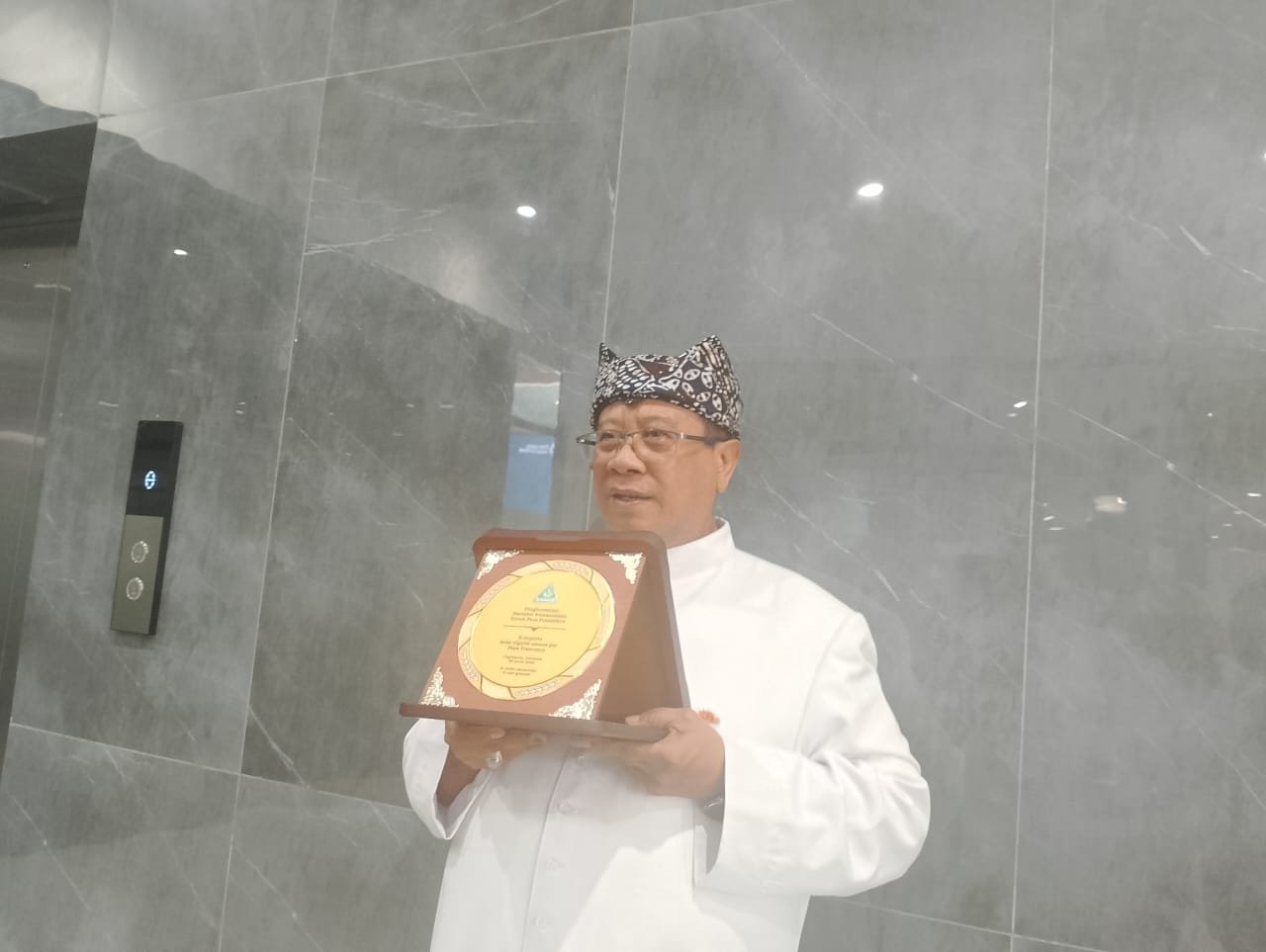 Romo Fadjar Tedjo Soekarno menunjukkan penghargaan perdamaian yang diberikan GP Ansor kepada mendiang Paus Fransiskus ke hadapan awak media di Kompleks Kampus UNU Yogyakarta, Sabtu (26/4/2025).