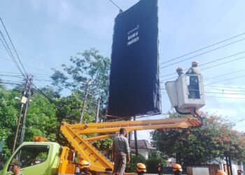 Satpol PP Kota Yogyakarta menutup baliho atau reklame yang dianggap ilegal, Selasa (13/5/2025).
