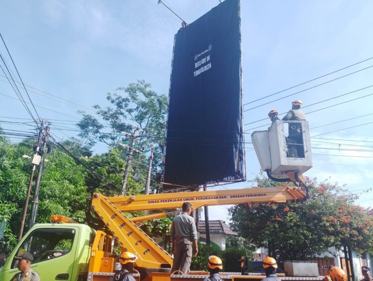 Satpol PP Kota Yogyakarta menutup baliho atau reklame yang dianggap ilegal, Selasa (13/5/2025).