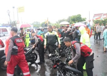 Petugas kepolisian mengevakuasi motor yang tertabrak KA Malioboro Ekspres di perlintasan kereta api di Kabupaten Magetan, Senin (19/5/2025)