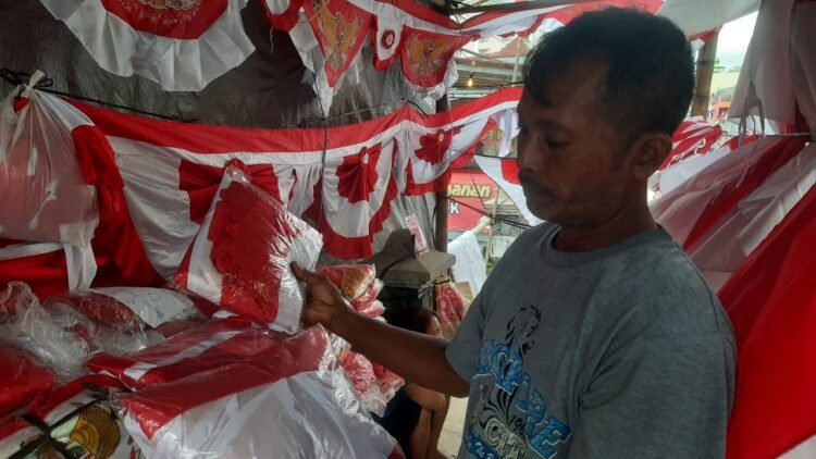 Iksan, penjual umbul-umbul dan bendera merah putih yang berjualan di Jalan Juminahan, Purwokinanti, Pakualaman, Kota Yogyakarta mengeluhkan sepinya pembeli tahun ini. (populi.id/Hadid Husaini)
