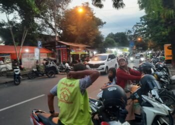 Seorang juru parkir menunggu kendaraan yang diparkir di sekitar kawasan Malioboro