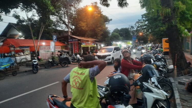 Seorang juru parkir menunggu kendaraan yang diparkir di sekitar kawasan Malioboro