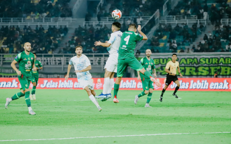Pemain PSIM Yogyakarta berebut bola dengan penggawa Persebaya Surabaya saat melakoni laga perdana kompetisi Super League yang berlangsung di Stadion Gelora Bung Tomo, Jumat (8/8/2025) petang.