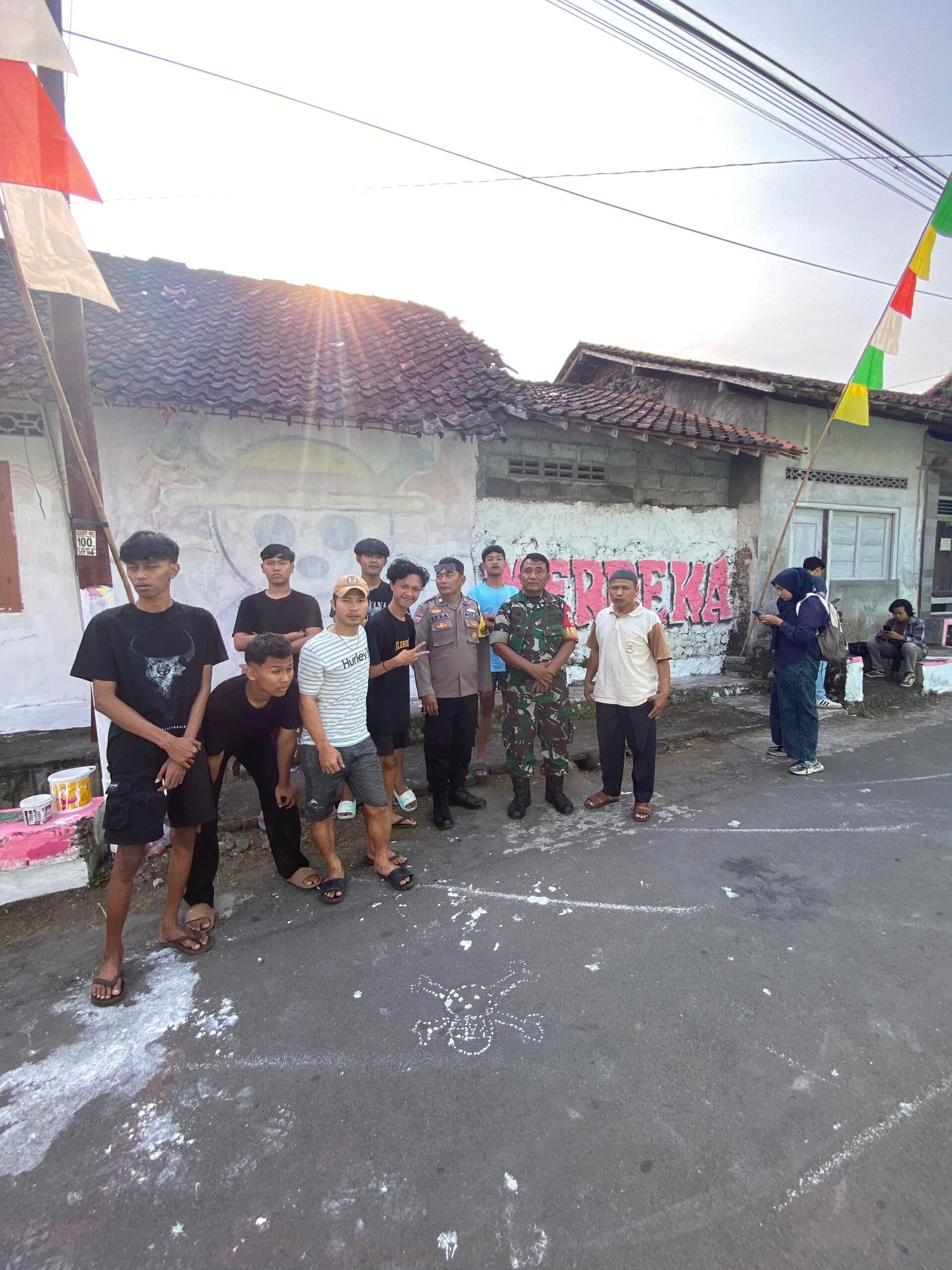 warga Temulawak, Triharjo, Sleman bersama Babinsa berfoto dengan lantar mural one piece yang telah dihapus, Kamis (7/8/2025)