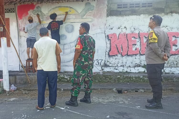 warga Temulawak, Triharjo, Sleman menghapus mural One Piece disaksikan Kepala Dukuh, Babinsa serta Bhabinkamtibmas, Kamis (7/8/2025)
