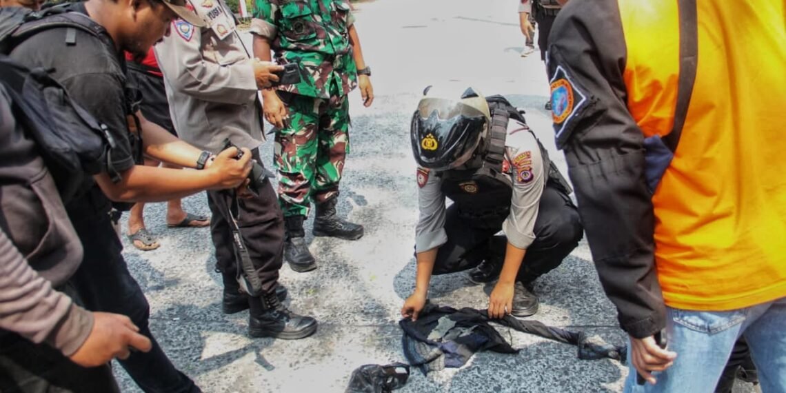 Petugas mengamankan serpihan mortir yang tercecer usai diledakkan di Dusun Besalen, Kalurahan Glagaharjo, Cangkringan, Sleman, Selasa (12/8/2025).