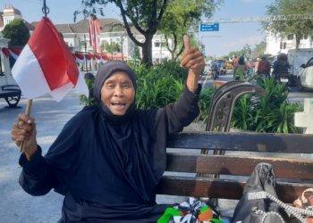 Pudjiastuti seorang veteran pejuang kemerdekaan memegang bendera merah putih yang dibagikan Kesbangpol Kota Yogyakarta, Jumat (1/8/2025)
