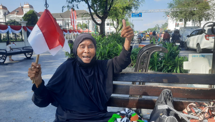 Pudjiastuti seorang veteran pejuang kemerdekaan memegang bendera merah putih yang dibagikan Kesbangpol Kota Yogyakarta, Jumat (1/8/2025)