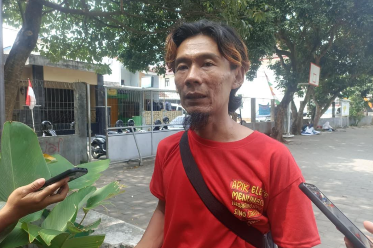 Satu di antara wali murid SMP Muhammadiyah 1 Mlati, Hanafi Hasan saat memberi keterangan terkait anaknya yang ikut keracunan diduga usai konsumsi MBG, Rabu (13/8/2025)