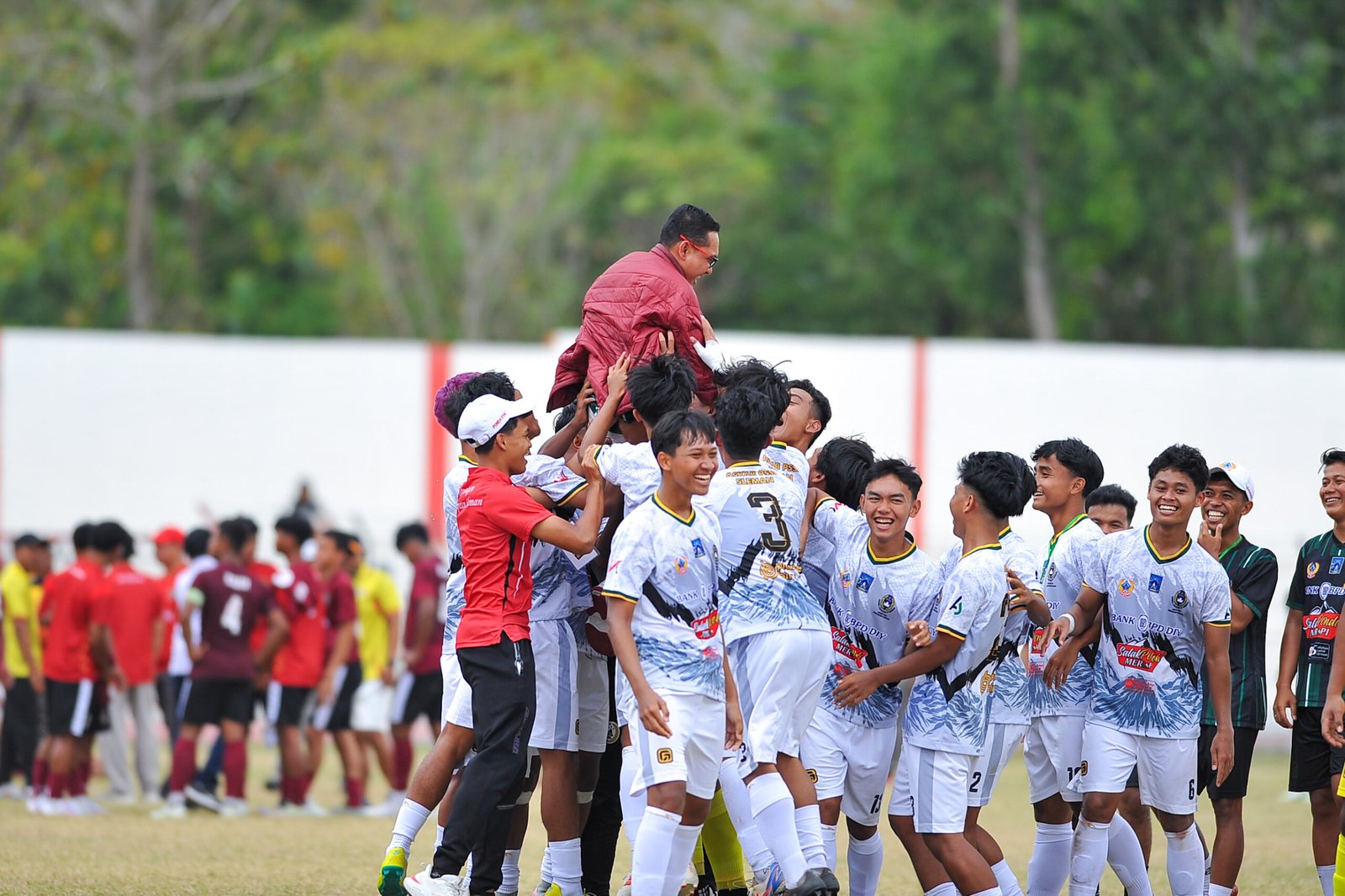 Ketua Askab PSSI Kabupaten Sleman, Wahyudi Kurniawan digendong para pemain putra cabor sepak bola usai meraih juara di Porda DIY ke-VII di Gunungkidul, Kamis (18/9/2025)