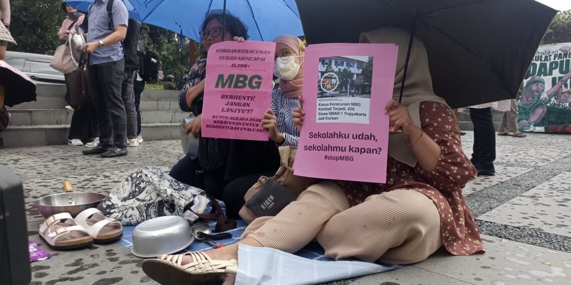 Massa aksi yang diinisiasi oleh Suara Ibu Indonesia menggelar aksi menuntut evaluasi program Makan Bergizi Gratis (MBG) di Bundaran UGM Yogyakarta, Jumat (17/10/2025) sore.