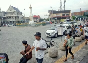 Wisatawan melintas di kawasan Tugu Yogyakarta.