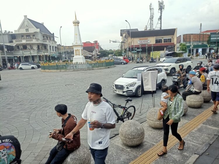 Wisatawan melintas di kawasan Tugu Yogyakarta.