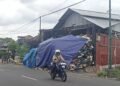 Pengendara motor melintas di depan sampah yang menumpuk di depo kawasan Lempuyangan, Kota Yogyakarta.