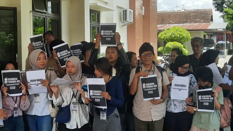 Keluarga dan rekan Perdana Arie Veroasa memberikan dukungan dengan membentangkan poster di Pengadilan Negeri (PN) Sleman, Senin (22/12/2025).