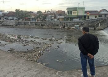 Warga mengamati suasana di sekitar kawasan Sungai Code, Mergangsan, Kota Yogyakarta.