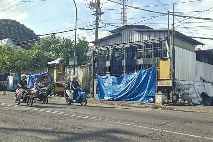 Sejumlah pengendara melintas di depan depo sampah Serangan yang masih terisi.