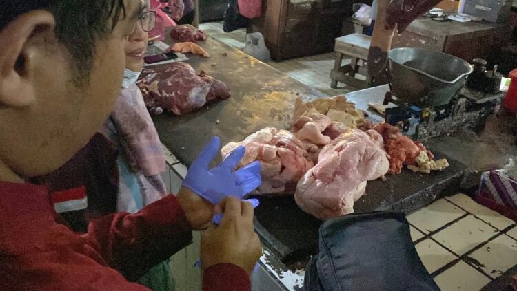 Petugas dari Dinas Pertanian dan Pangan Kota Yogyakarta saat memeriksa kondisi daging sapi di Pasar Beringharjo.