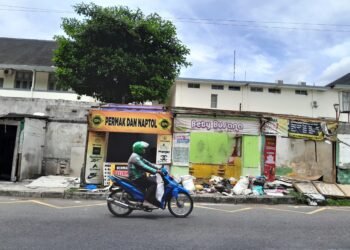 pengendara melintas di depan bangunan bekas lapak penjahit permak jeans di Jalan Dr Sardjito, Kelurahan Terban, Kemantren Gondokusuman, Kota Yogyakarta, Kamis (22/1/2026).