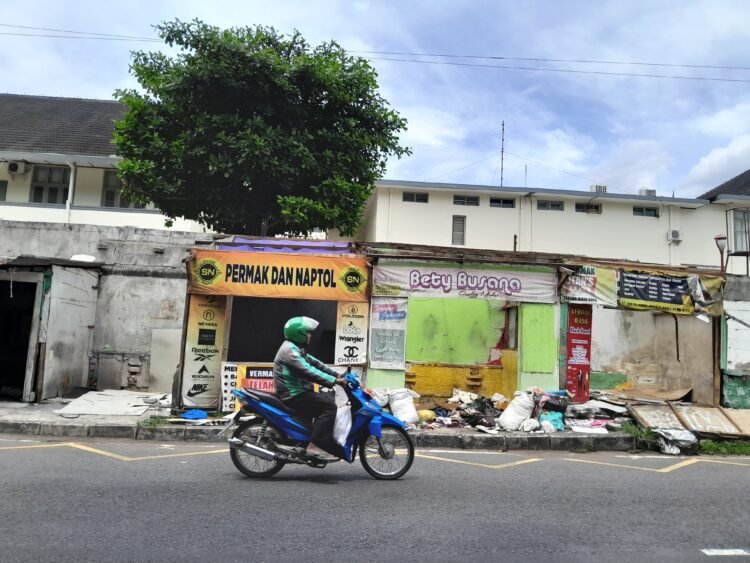 pengendara melintas di depan bangunan bekas lapak penjahit permak jeans di Jalan Dr Sardjito, Kelurahan Terban, Kemantren Gondokusuman, Kota Yogyakarta, Kamis (22/1/2026).