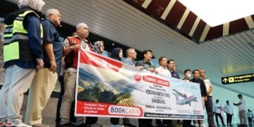 Bupati Kulon Progo Agung Setyawan dan jajaran Wings Air membentangkan spanduk sebagai penanda dibukanya kembali rute penerbangan Kulon Progo-Bandung di YIA, Rabu (11/2/2026)