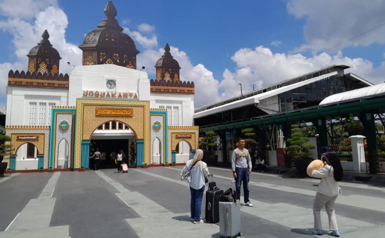 Sejumlah pemudik tampak meluangkan waktu untuk berfoto di depan fasad Stasiun Tugu Yogyakarta yang dihiasi ornamen bernuansa Ramadan, pada Senin (16/3/2025).