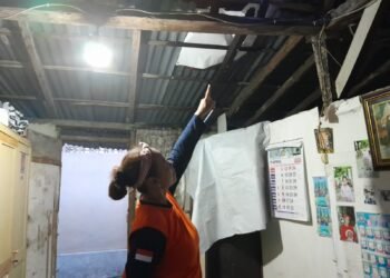 Warga Kampung Jogoyudan, Rika, menunjukkan atap rumahnya yang terdampak hujan deras dan angin kencang pada Minggu (5/4/2026).
