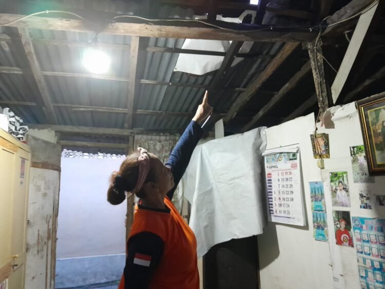 Warga Kampung Jogoyudan, Rika, menunjukkan atap rumahnya yang terdampak hujan deras dan angin kencang pada Minggu (5/4/2026).