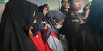 Tersangka kekerasan kepada balita di Daycare Little Aresha saat dibawa ke mobil tahanan.