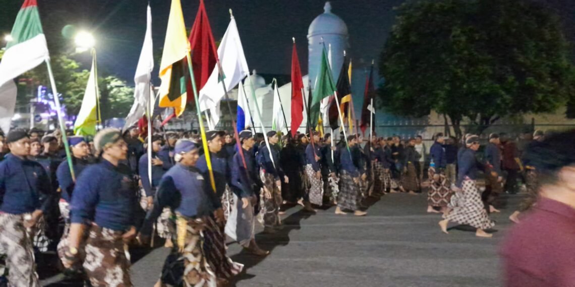 Ribuan orang tampak khidmat mengikuti ritual Tapa Bisu atau Hajad Kawula Dalem Lampah Budaya Mubeng Beteng saat melintas di Pojok Benteng Timur, Kota Yogyakarta, Rabu (17/6/2026).
