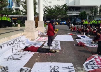 Massa aksi IMM DIY melakukan tabur bunga sebagai simbol duka terhadap situasi negara saat ini dalam gelaran aksi demonstrasi di DPRD DIY, Senin (22/6/2026).