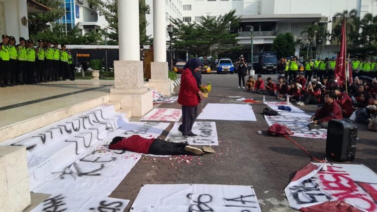 Massa aksi IMM DIY melakukan tabur bunga sebagai simbol duka terhadap situasi negara saat ini dalam gelaran aksi demonstrasi di DPRD DIY, Senin (22/6/2026).