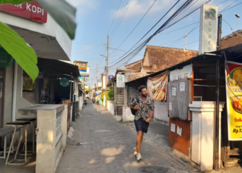 Sejumlah wisatawan mancanegara sedang melintas di Gang Hansip Karno Waluyo yang dijuluki Gang Internasional di Kelurahan Tegalpanggung, Kemantren Danurejan, Kota Yogyakarta, Minggu (28/6/2026).