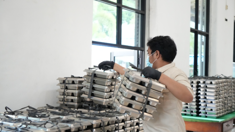 Petugas menyiapkan paket makanan bergizi gratis di Satuan Pelayanan Pemenuhan Gizi (SPPG).