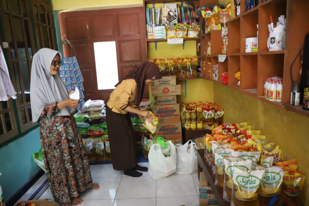 Seorang anak mengambil kebutuhan pokok di warung sembako gratis bagi anak yatim binaan Yan Budi Nugroho di Desa Tridadi, Kecamatan Loano, Kabupaten Purworejo, Jawa Tengah.